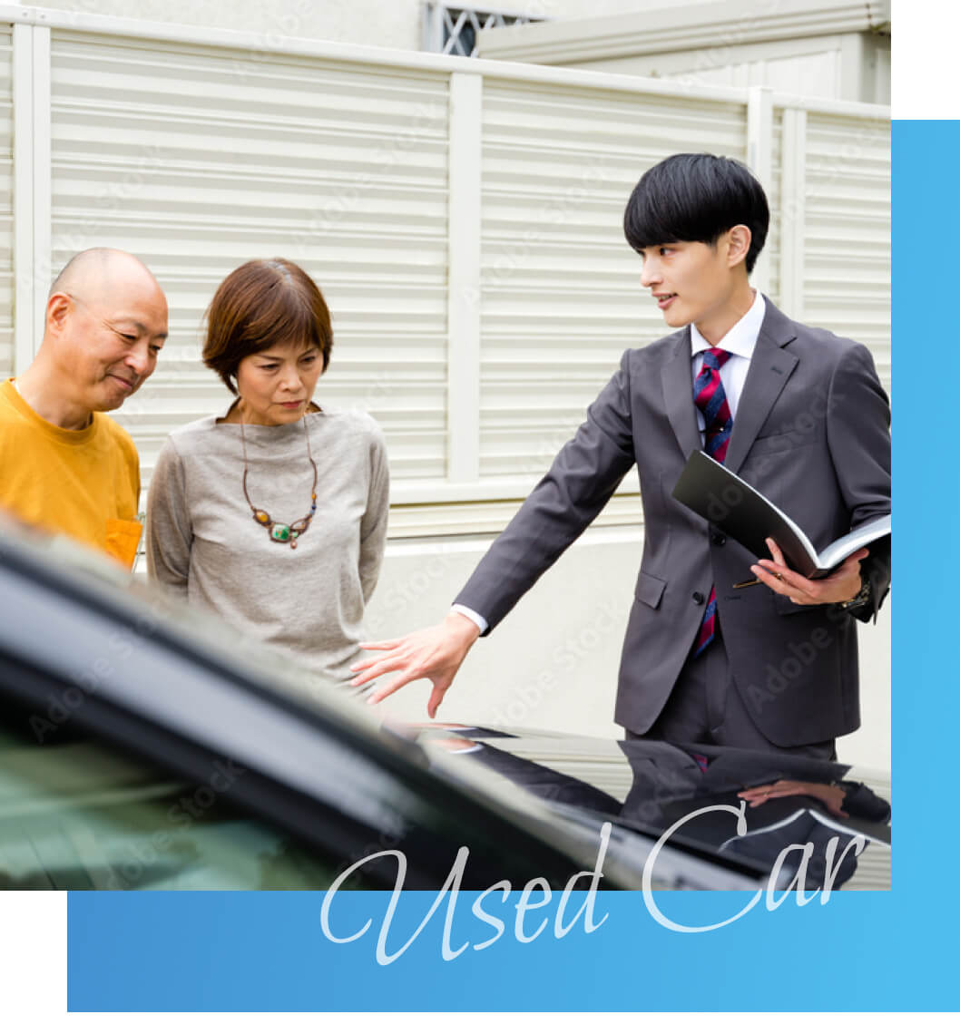 車の前で商談する営業マンと老夫婦